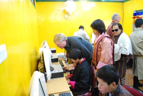 photo: Computer centre opening, Morten. Tshering and Kuenga helping pupils use the computers.